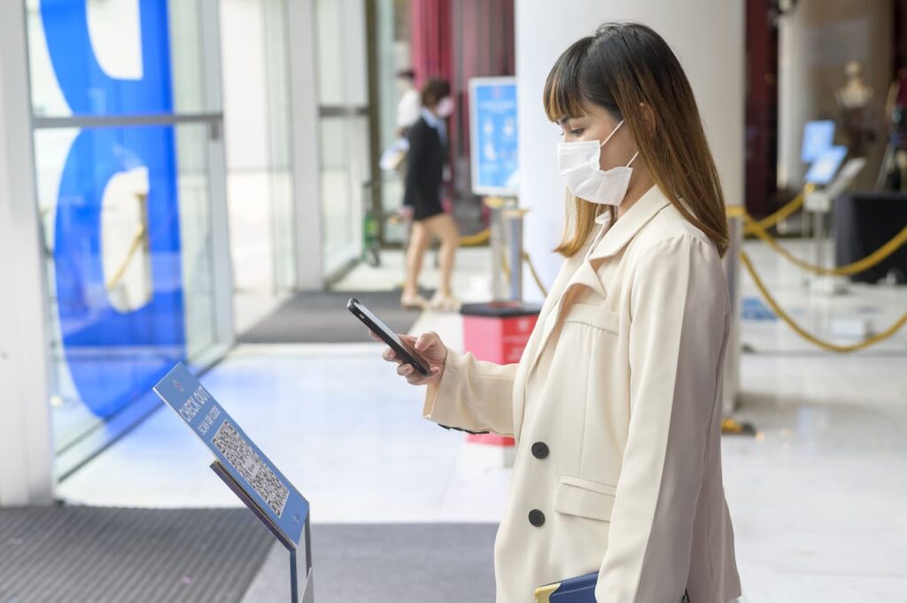 Woman at an event scanning a QR code from print with her smartphone