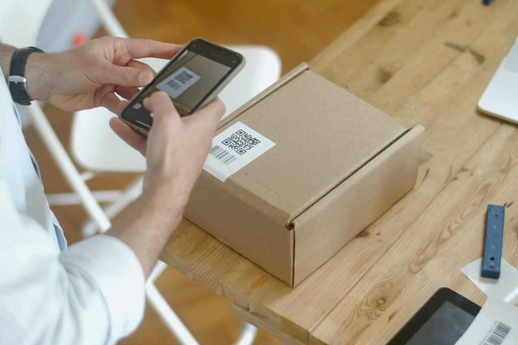 Man scanning a QR code from a package with a smartphone