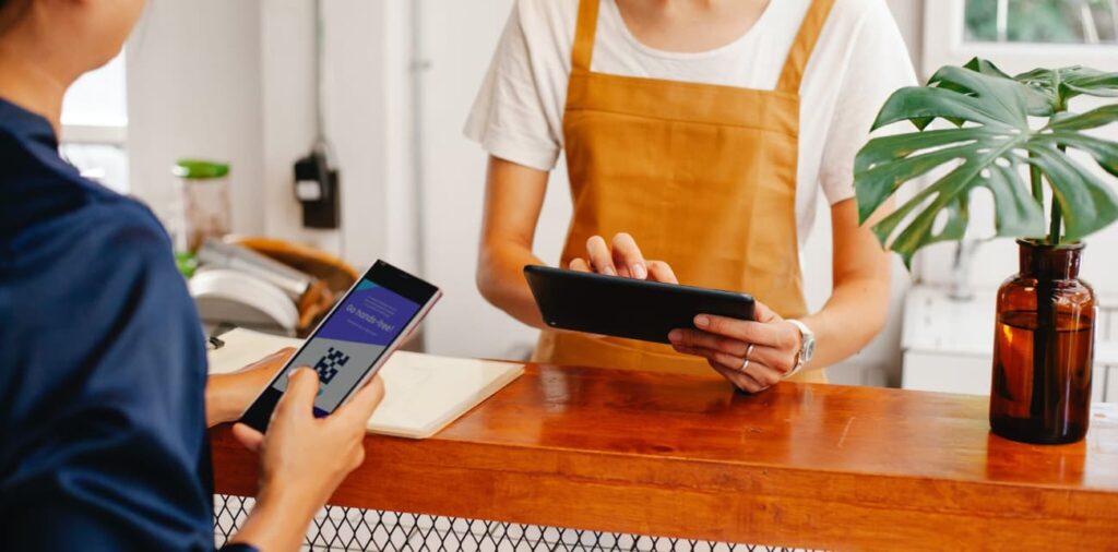 Woman scanning a QR code to make a payment in a restaurtant