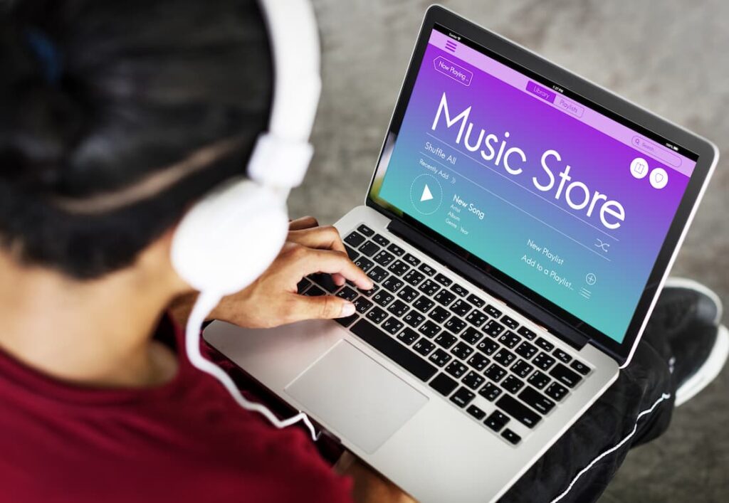 A man accessing a music store to download a song on a mac computer